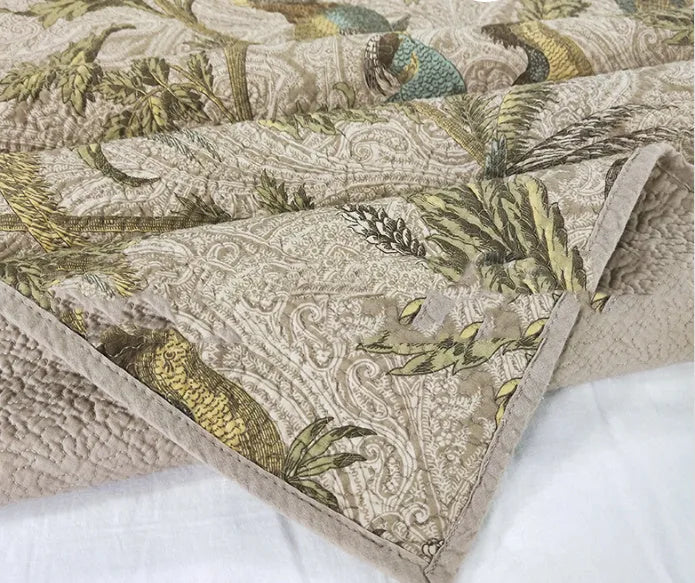 Blue American floral pattern cotton quilted bedspread set of three pieces laid on a bed.