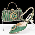 Women's black high-heel ankle strap sandal with rhinestone flower buckle and matching hard clutch bag.