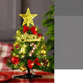 Mini Christmas tree 30cm tall in PVC, colour A, on a tabletop with festive background