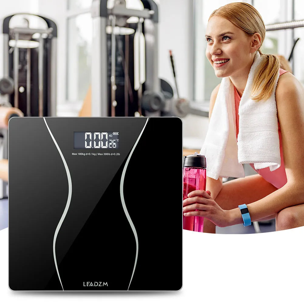 Black electronic body scale with LCD display showing weight measurement up to 180kg