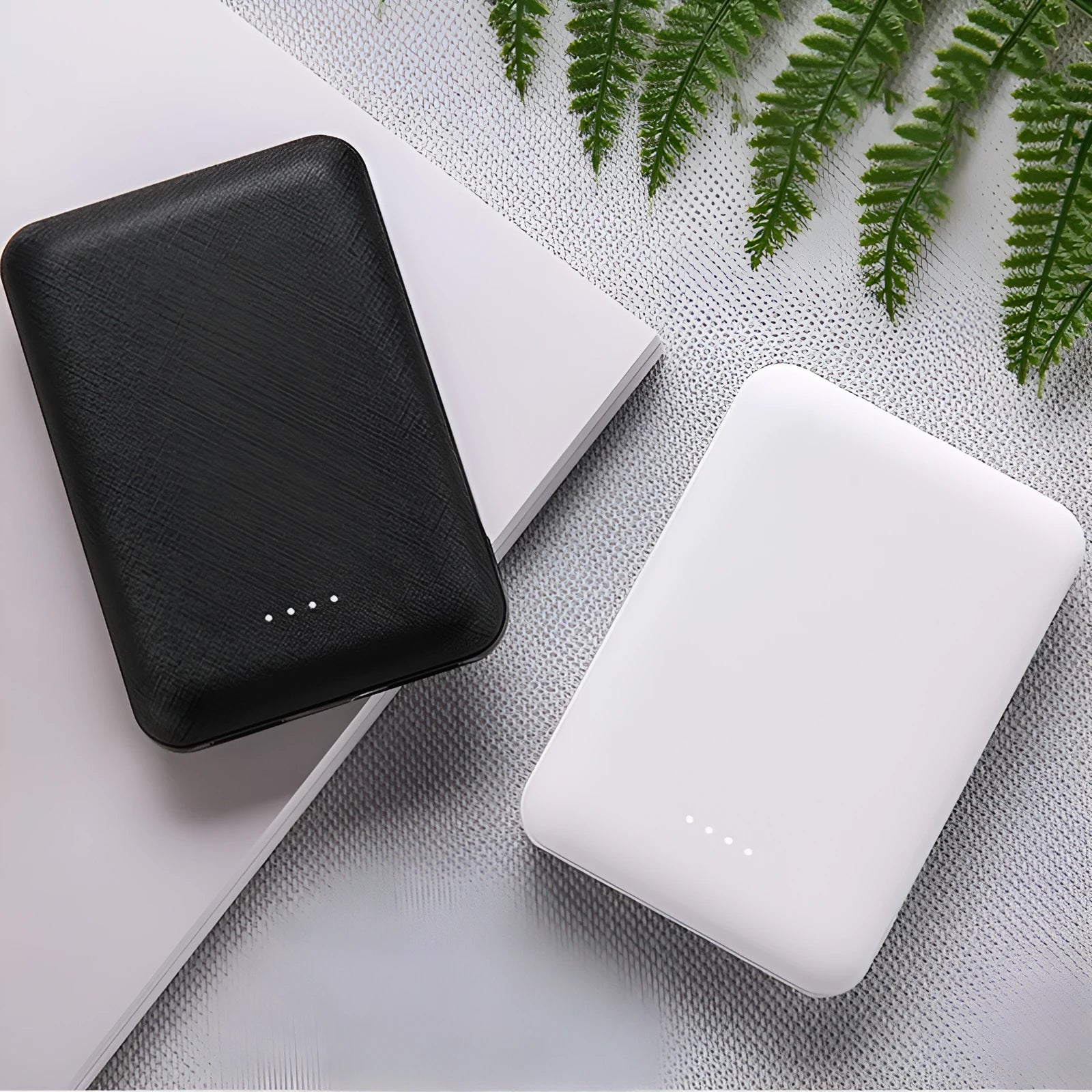 Ultra-thin 10,000mAh power bank measuring 90x63x22mm with multiple USB ports in black or white colour