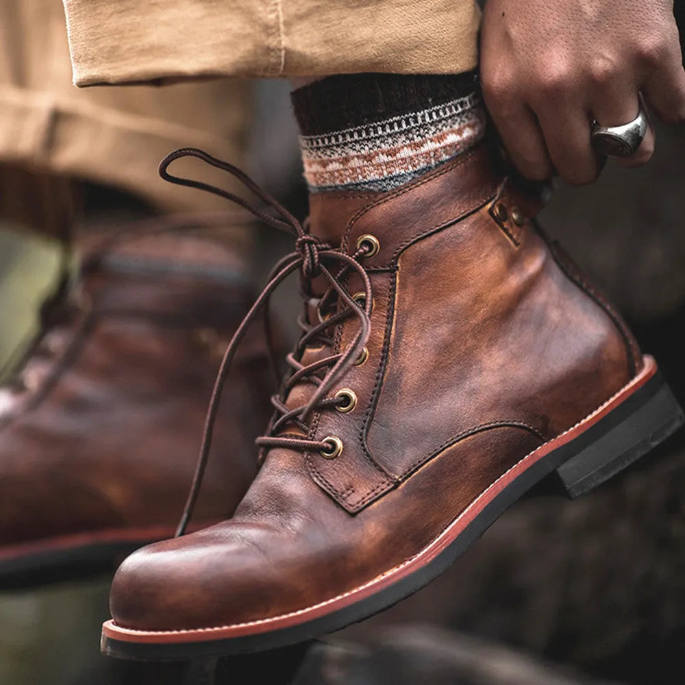 Men's black military Martin boots with rubber sole and lace-up closure on a work site