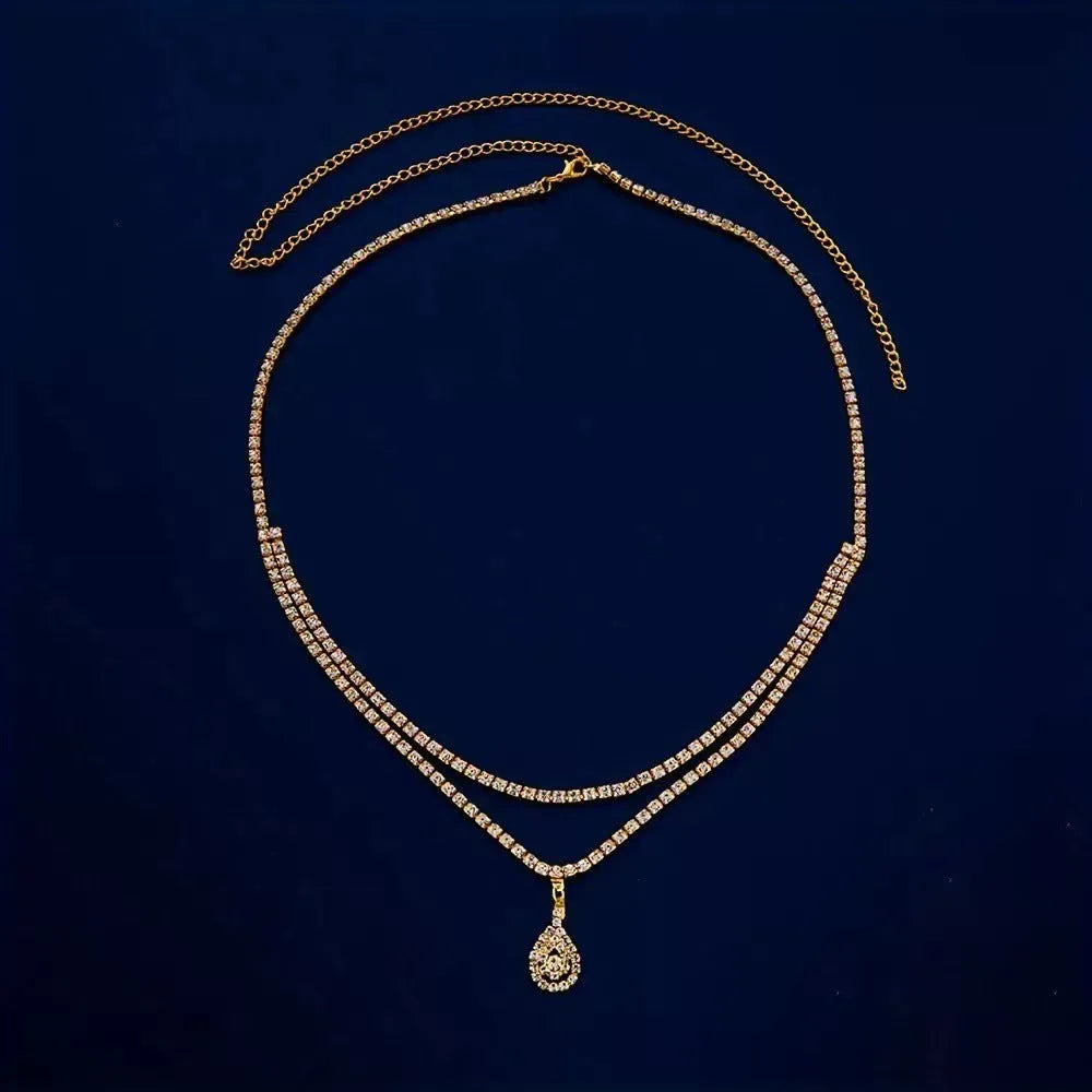 Gold rhinestone waist chain with water drop pendant and tassel detailing on adjustable 115 cm chain