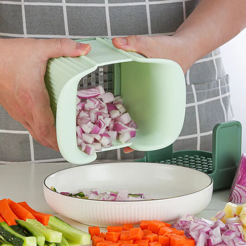 Green multifunctional vegetable chopper with stainless steel blades for dicing onions and slicing cucumbers.