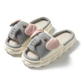 A pair of elephant grey open-toe linen slippers for couples on a plain background.