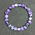 Close-up of a bohemian-style bracelet with 8mm natural agate beads and glass accents on a wrist.