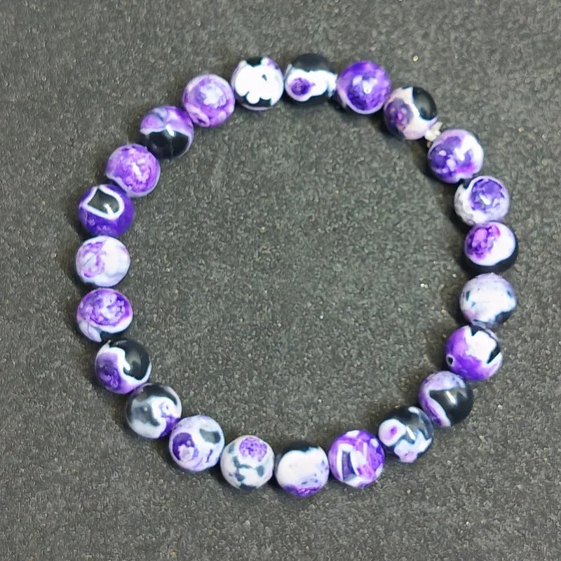 Close-up of a bohemian-style bracelet with 8mm natural agate beads and glass accents on a wrist.