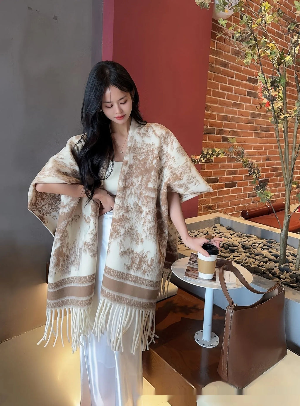 Women's tassel-trimmed polyester scarf cape worn as a shawl, shown in one of five available colours.