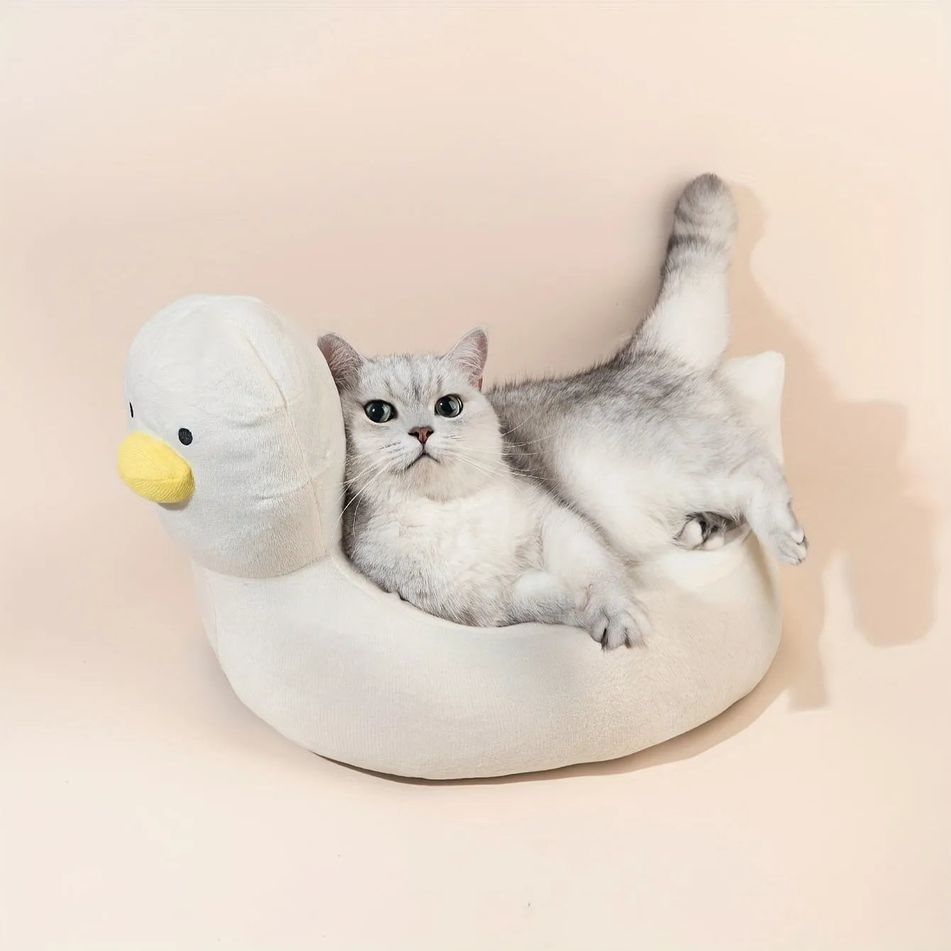 Blue duck-shaped fluffy pet bed for small dogs and cats on a wooden floor.