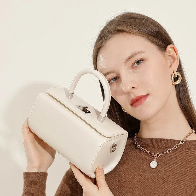 Brown leather women's crossbody bag with a box shape and clamshell opening, shown with interior phone and file pockets.