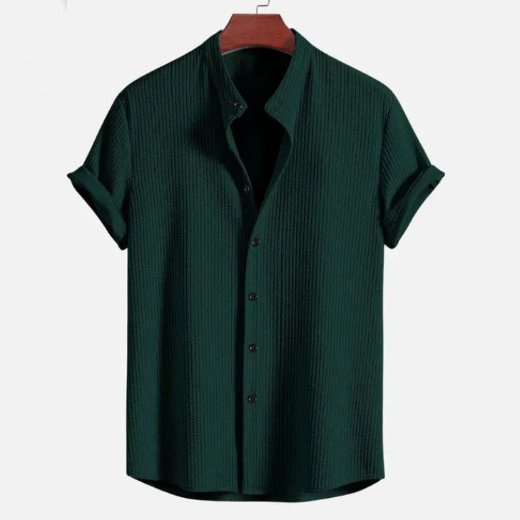 Man wearing a loose-fitting short sleeve summer shirt in a solid colour, showing the relaxed fit and short sleeves.