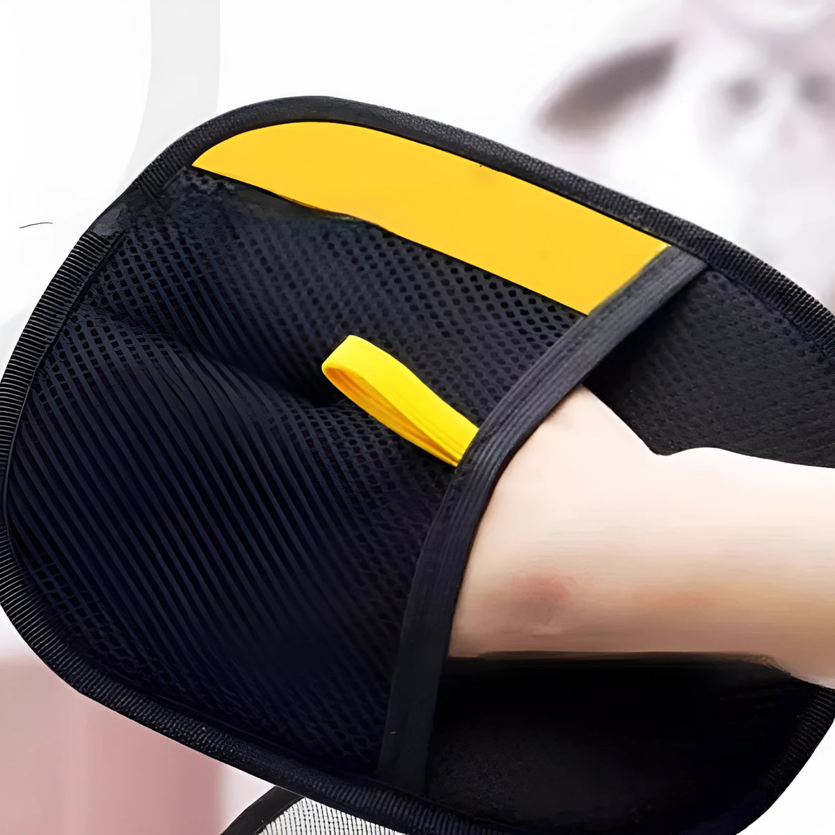 Yellow cat hair removal glove worn on hand for wiping cat hair from sofa, carpet or car seat