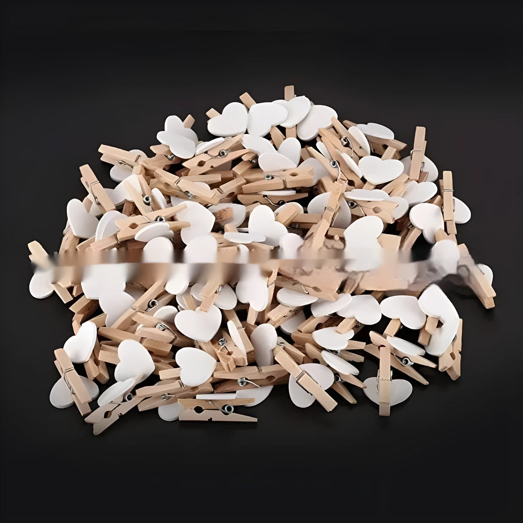 Five small wooden heart-shaped clips in red, pink, yellow, white, and rose red colours on a neutral background.