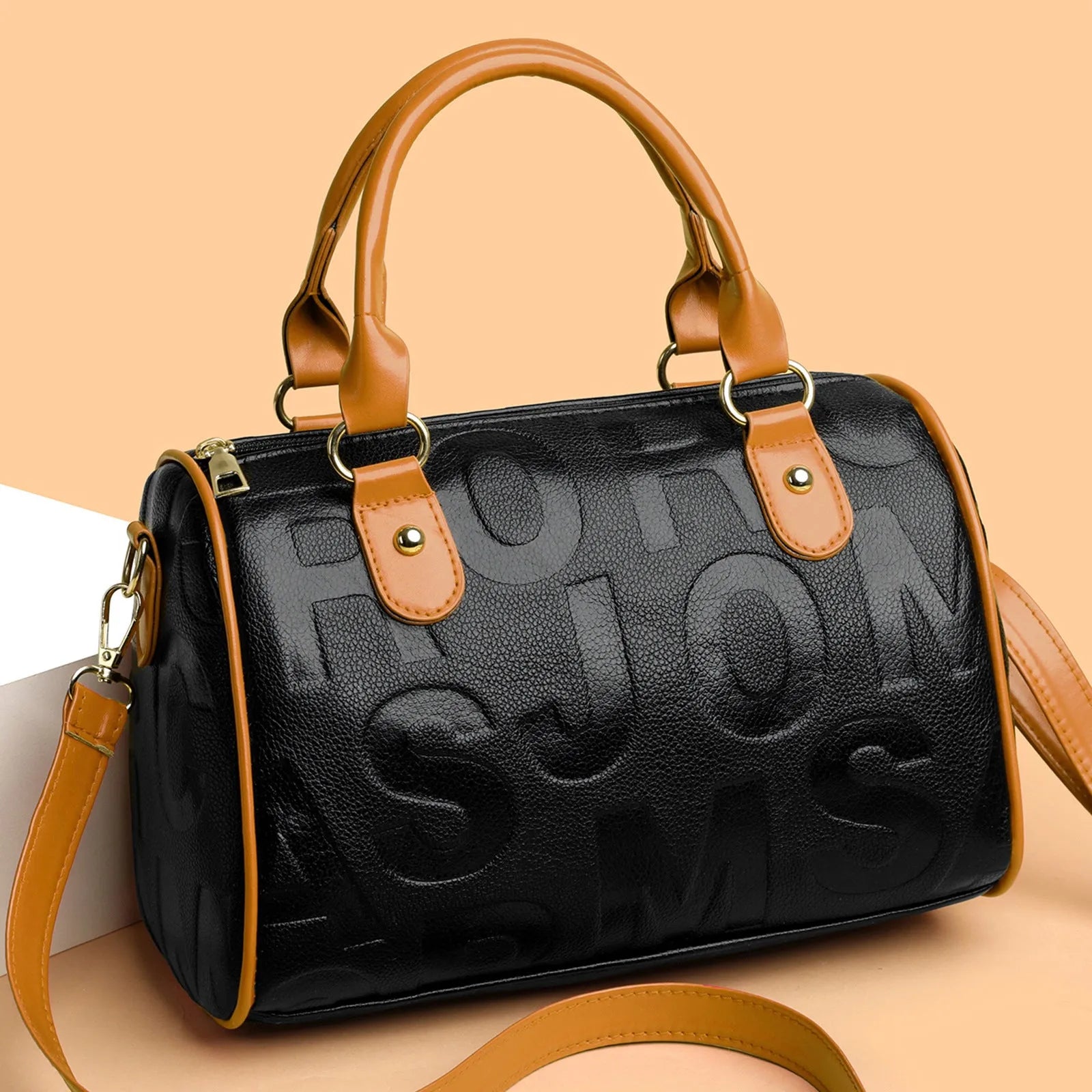 Brown cylindrical crossbody bag with three adjustable shoulder straps showing suitcase shape