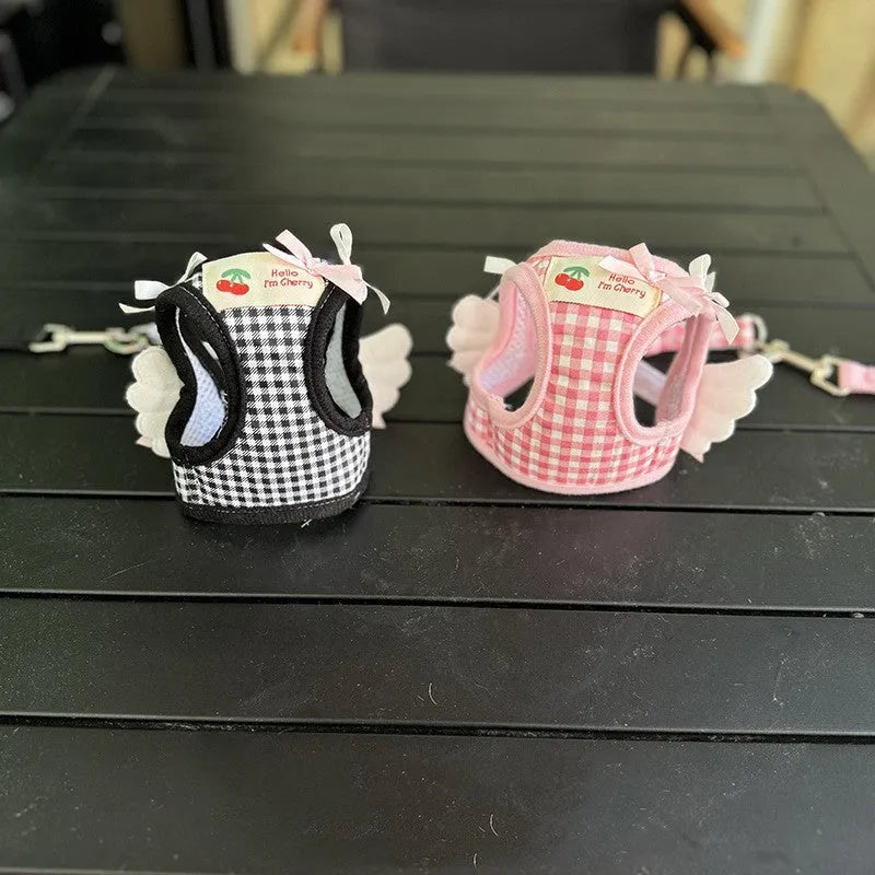 Pink and black cotton chest and back hand holding rope for a small dog on a walk.