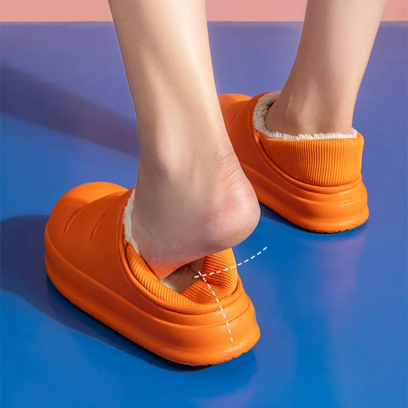 Yellow women's EVA overshoe slippers with plush lining and a textured non-slip sole on a wooden deck.