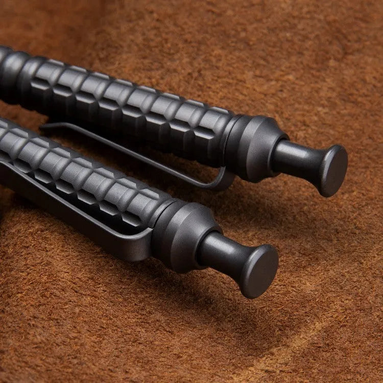 Gunmetal grey titanium alloy tactical pen with push-action button, shown in its gift box.