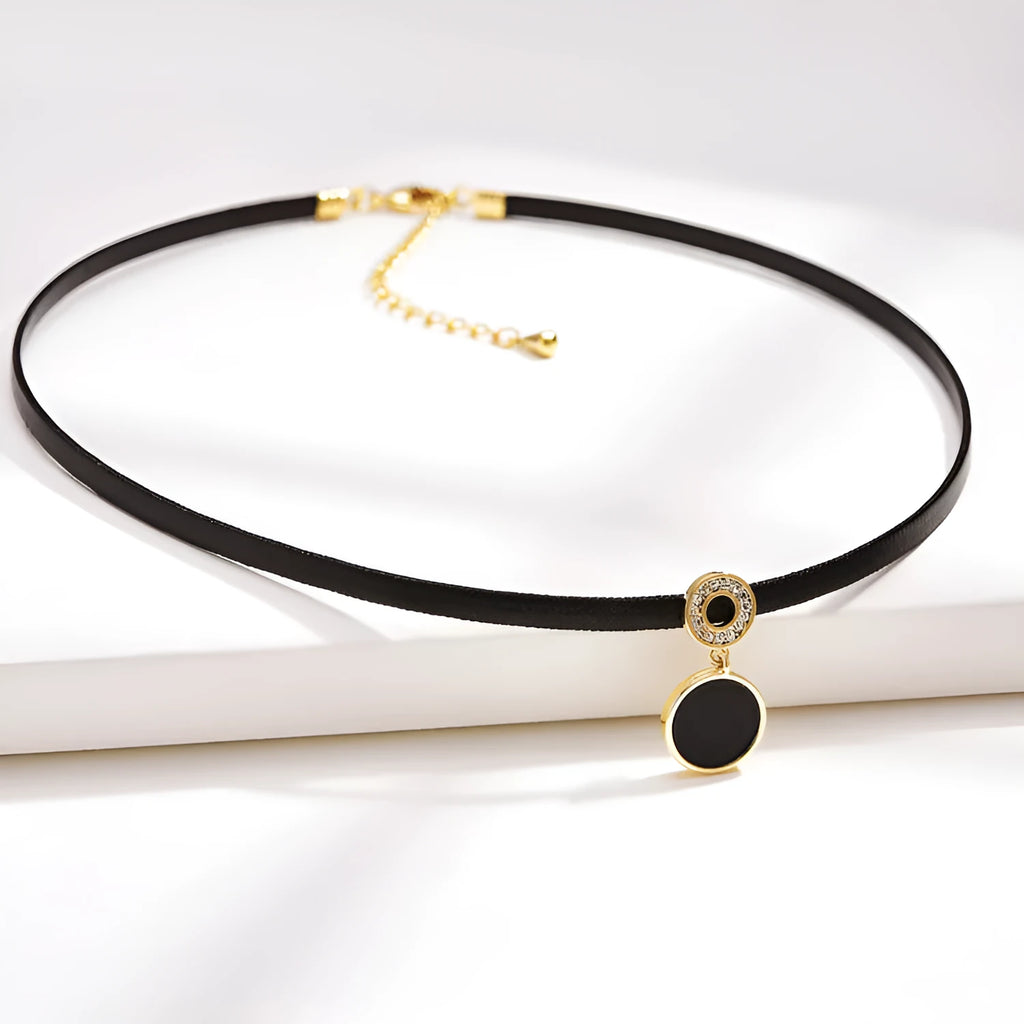 Women's short black clavicle necklace with round gold alloy pendant and leather rope chain on display