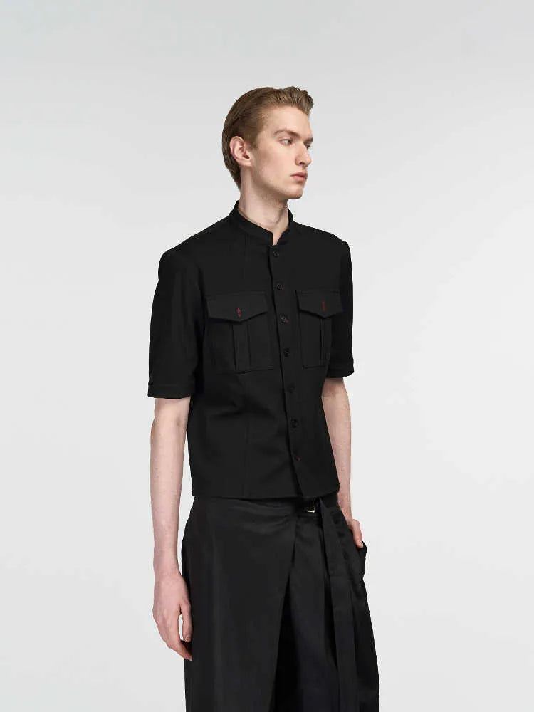 Black handmade loose-fit half sleeve hunting shirt with a shirt collar on a hanger.