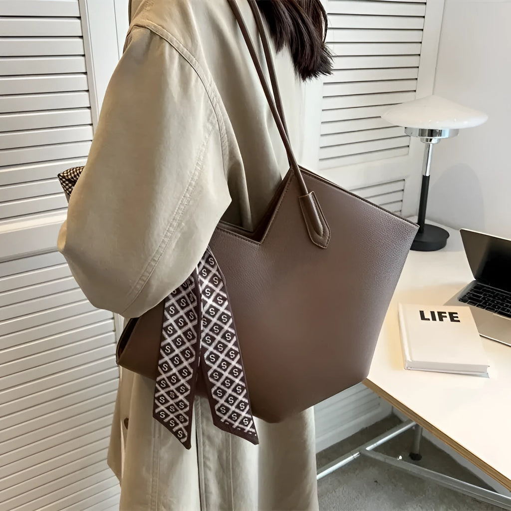 Women's large beige PU leather shoulder bag with a square shape and single handle on a neutral background.