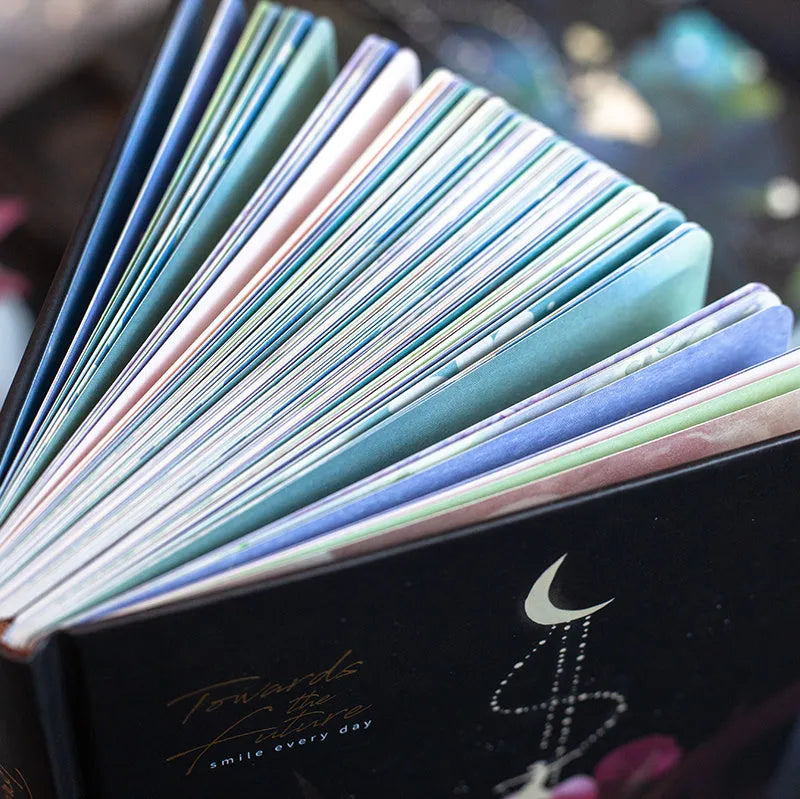 A5 notebook with luminous cover and silver foiling, open to show pages with colour illustrations.