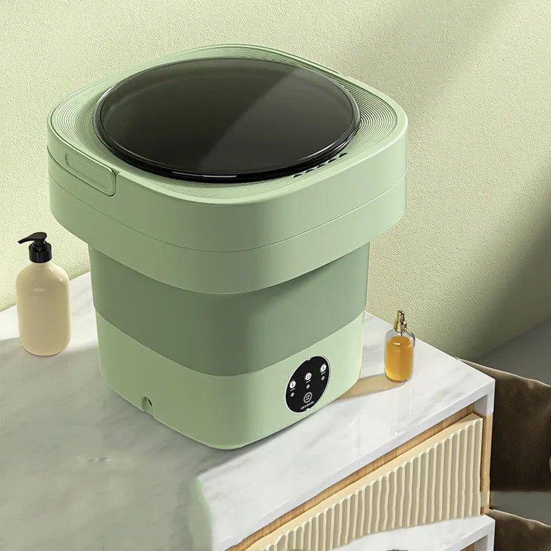 Green foldable portable mini washing machine for socks and underwear with drain pipe and basket.