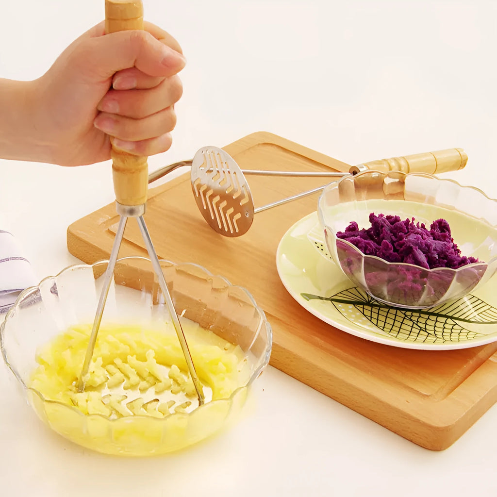 Manual potato masher with flower-shaped iron plated head and wooden handle on white background