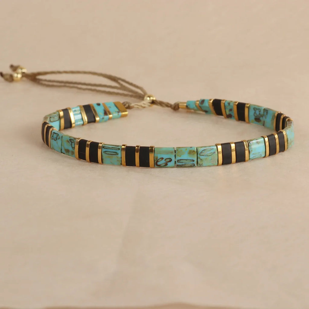 Geometric round glass bead bracelet in five colour options on a wrist.