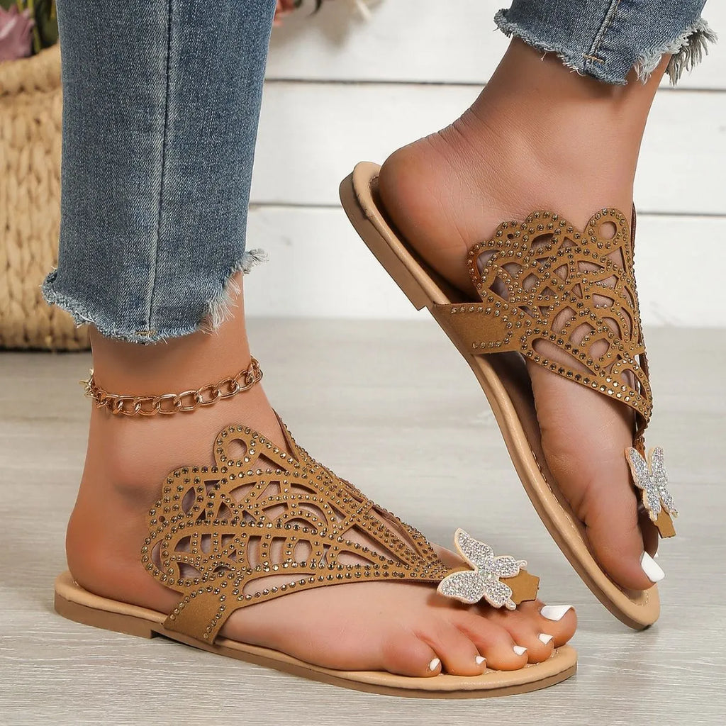 Women's black slip-on sandals with rhinestone decoration and a flip-toe, hollow design.