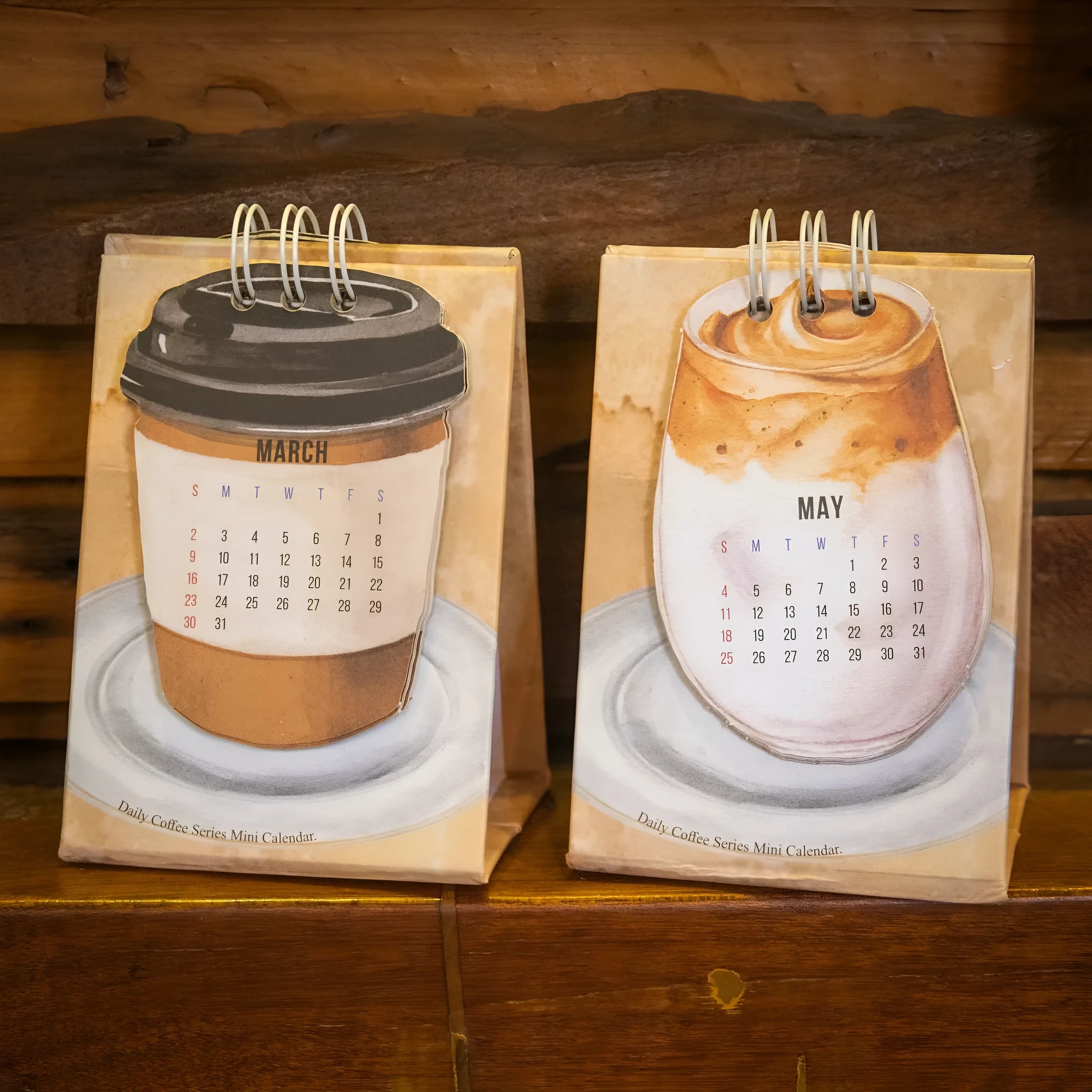Small 2025 mini desk calendar open to a daily page, showing modern simple design on a desk.