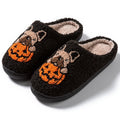 Black Halloween slippers with pumpkin design featuring soft plush upper and non-slip rubber soles.