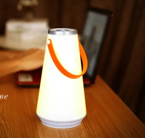 White rechargeable LED lantern night light on a wooden bedside table.