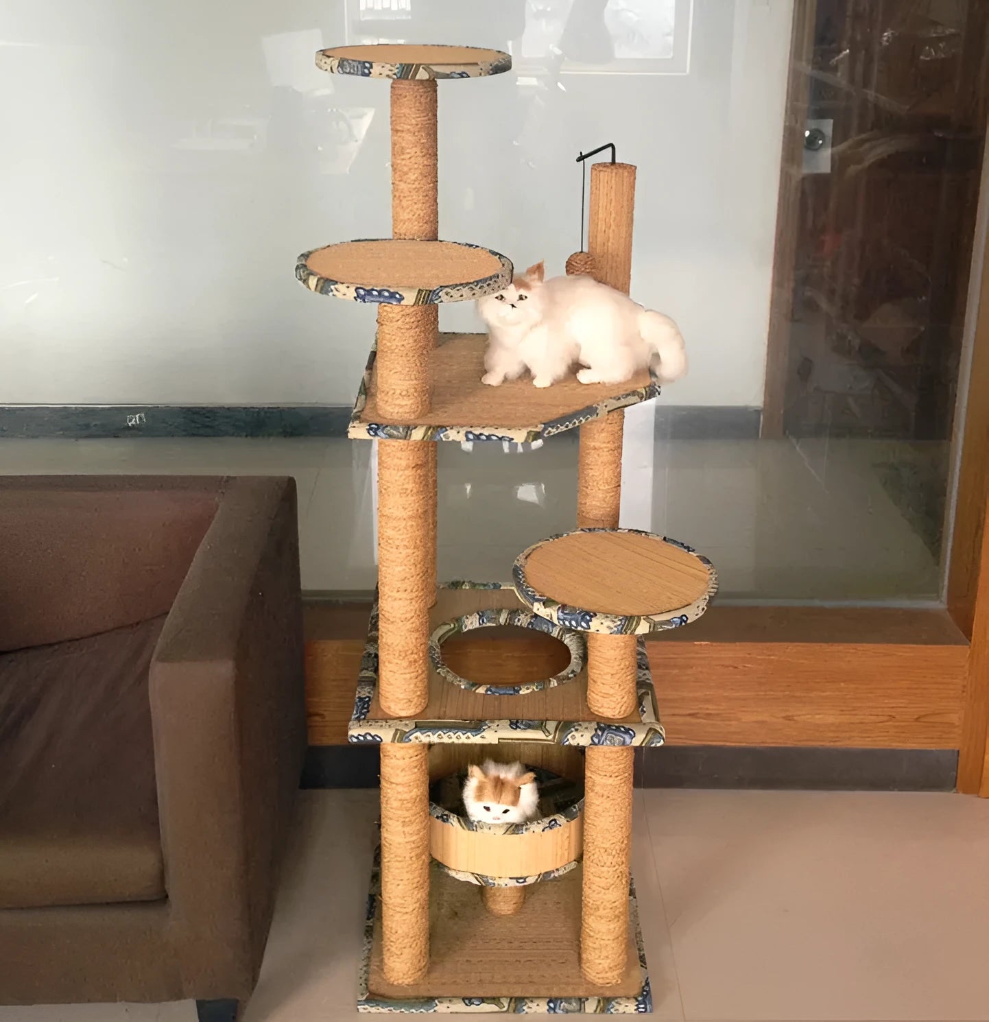 Cat playing on a natural wheat straw scratch board climbing frame with multiple levels
