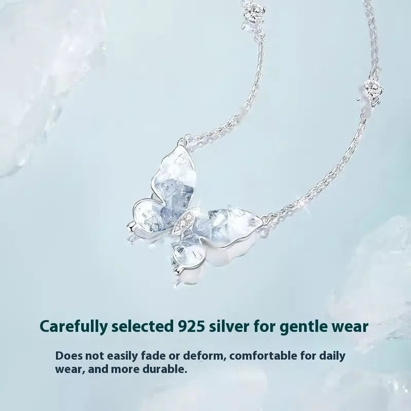 Close-up of a silver necklace with a detailed ice rain butterfly pendant on an O-ring chain.