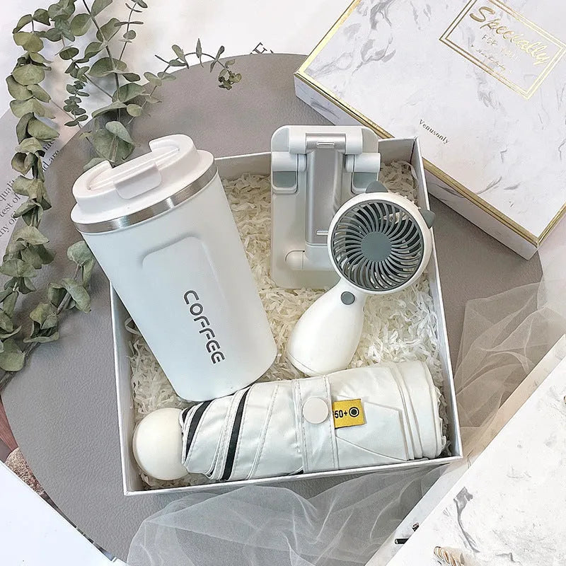 Metal business gift set with bracket, keychain, umbrella, cup, and data cable on a neutral background