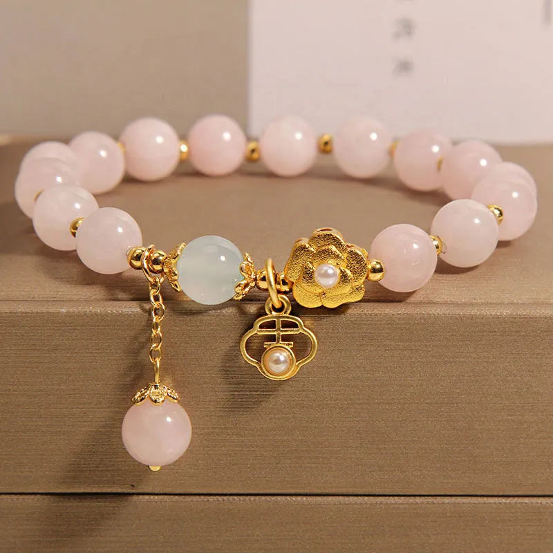Women's pink crystal flower bracelet with clear crystal stones forming floral design pattern.