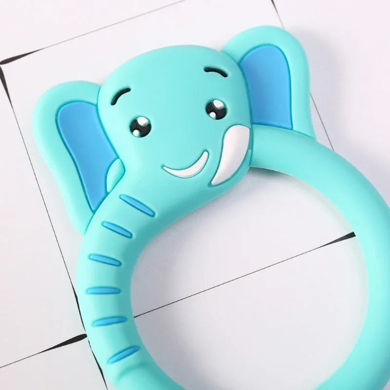 Three silicone baby molar teethers in brown, blue, and yellow on a light background