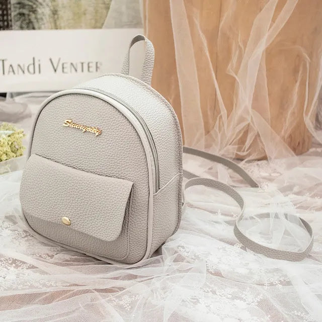 Compact black PU leather women's small backpack with a slim profile and zipper closure.