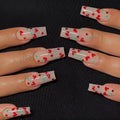 Red diamond and small cherry pattern nail art stickers on a sheet, with a tube of glue.