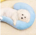 Blue U-shaped cat sleeping mat with integrated moon-shaped neck pillow on a wooden floor.