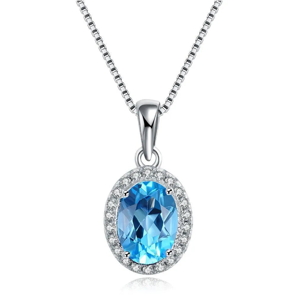Four-piece sterling silver jewellery set with blue topaz: geometric earrings, ring, pendant, and necklace.