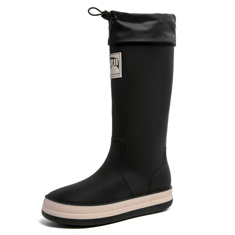 A pair of solid-colour high-tube PVC rain boots with a low heel on a plain background.