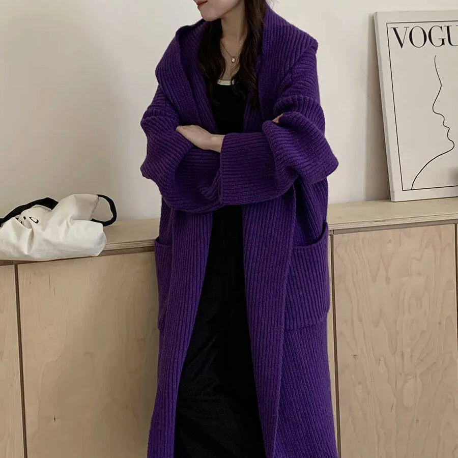 Loose grey hooded cardigan coat for women with long sleeves on a hanger.