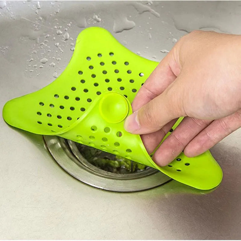 Three silicone starfish-shaped sink drain filters in white blue and green with suction cups