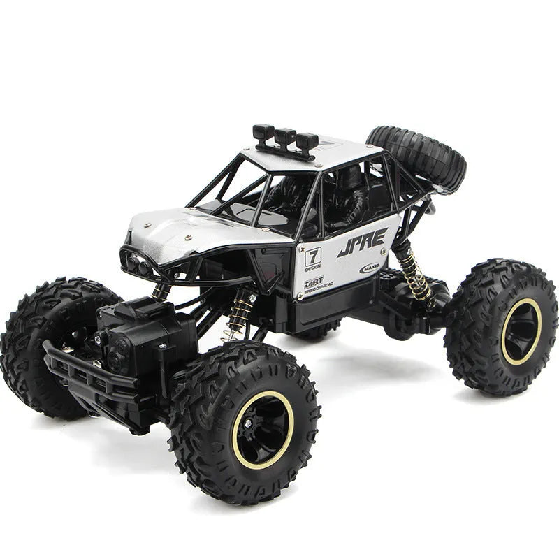 Black and silver remote control off-road car on rough terrain showing four-wheel drive and climbing capability.