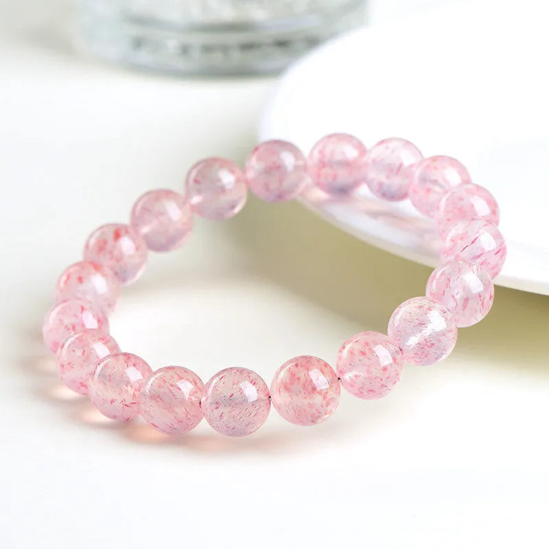 Natural strawberry quartz crystal bracelet with white water geometric beads on elastic cord.