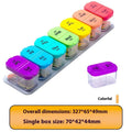 Large white and rainbow coloured plastic pill box with 14 removable compartments open on a table.
