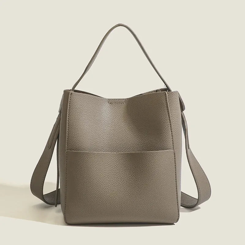 Soft PU bucket messenger bag in elephant gray with visible sewing line detailing, outer sandwich pocket, and single shoulder strap.