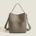 Soft PU bucket messenger bag in elephant gray with visible sewing line detailing, outer sandwich pocket, and single shoulder strap.