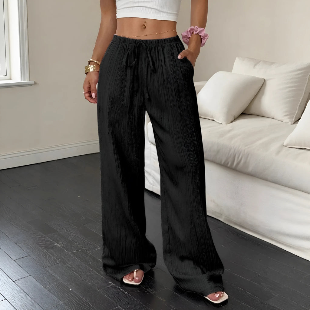 Women's black wide-leg trousers with a front lace-up waist detail on a mannequin.